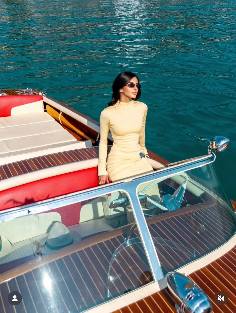 Boat on turquoise water; Rahaf in pale-yellow dress