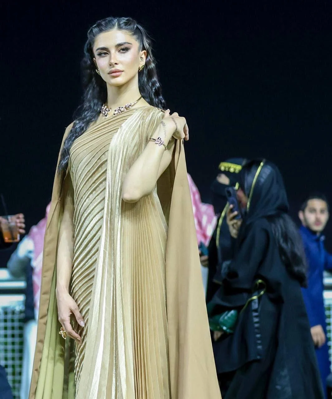 Gold gown with cape at Saudi Cup