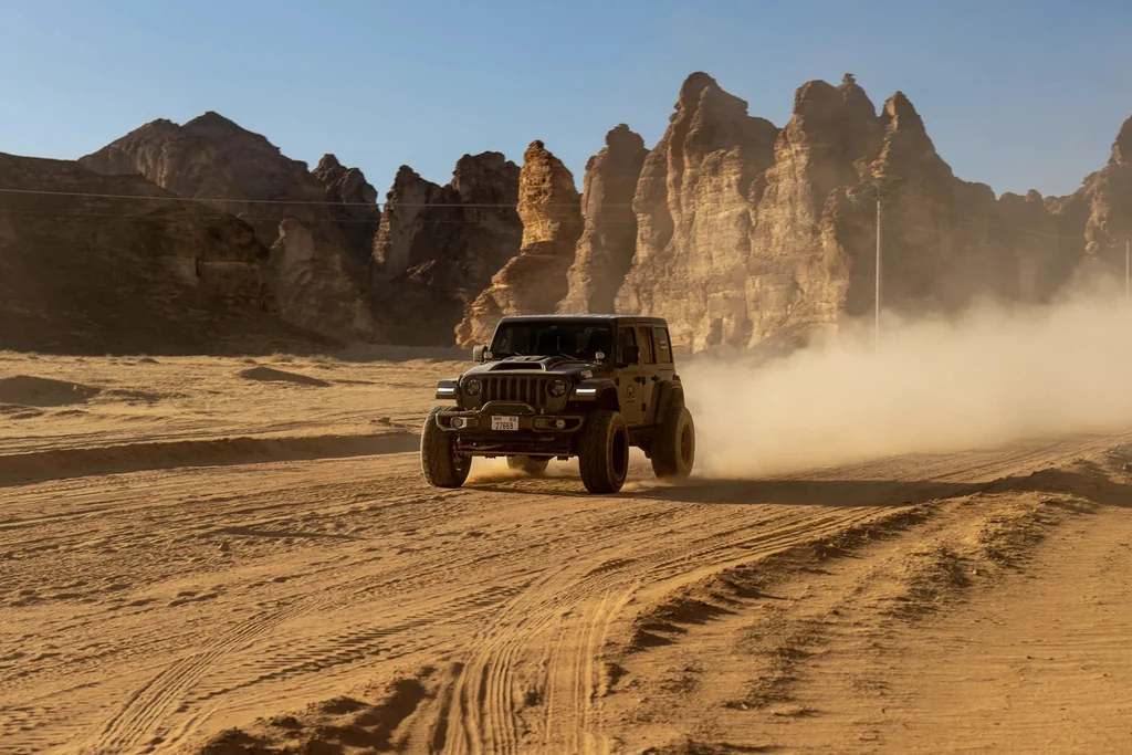 A rally vehicle crossing a rocky desert landscape