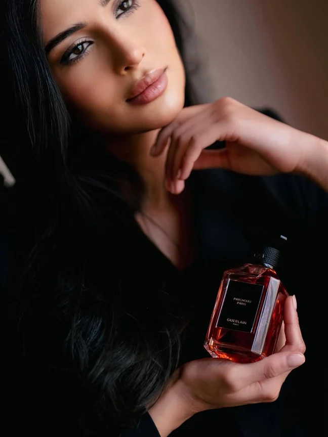 Guerlain portrait with perfume bottle at waist