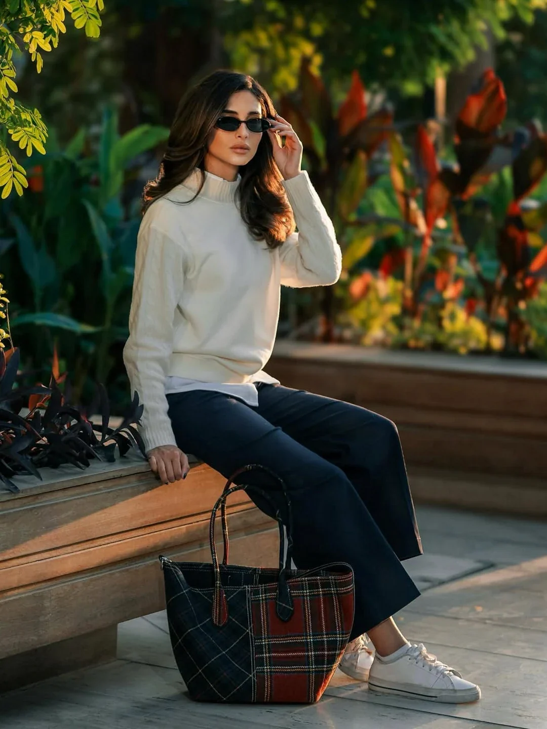 Rahaf in a pale knit and jeans with a checked Polo Ralph Lauren tote