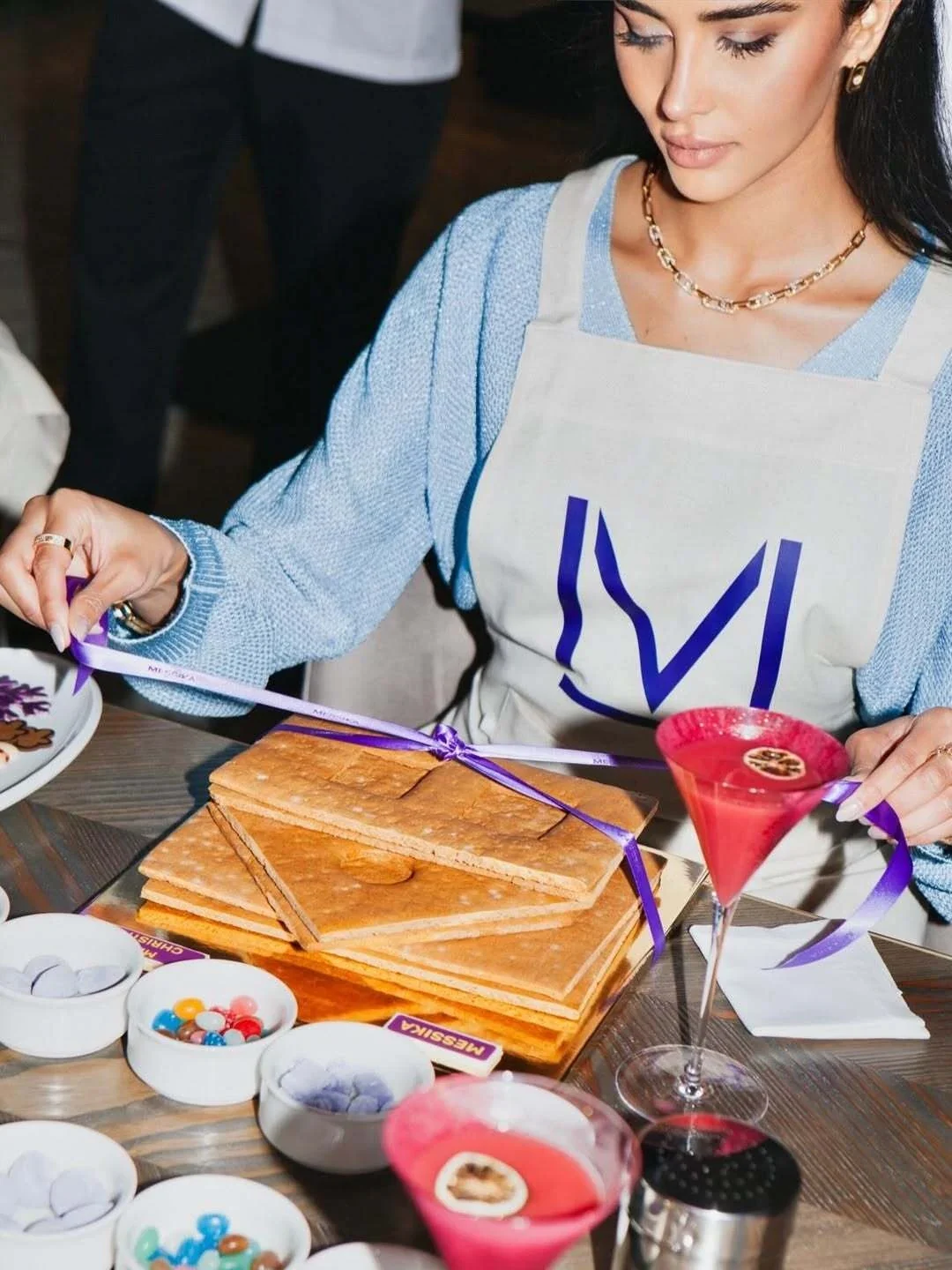 Rahaf painting at a table during a Messika event