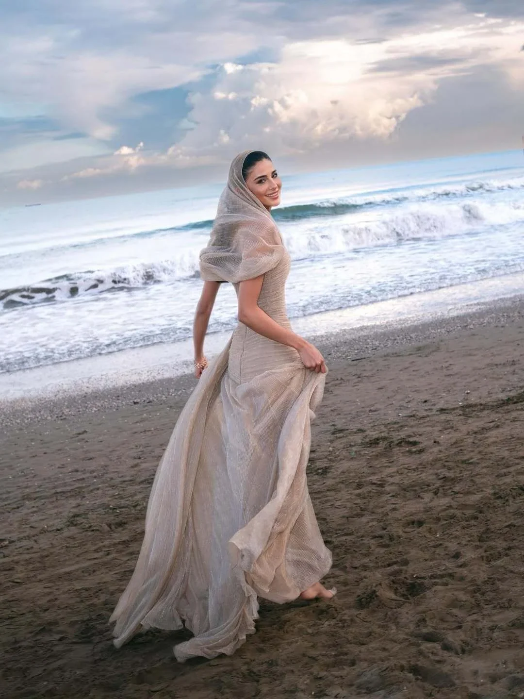 Rahaf on the beach in Venice in a pale gown and veil