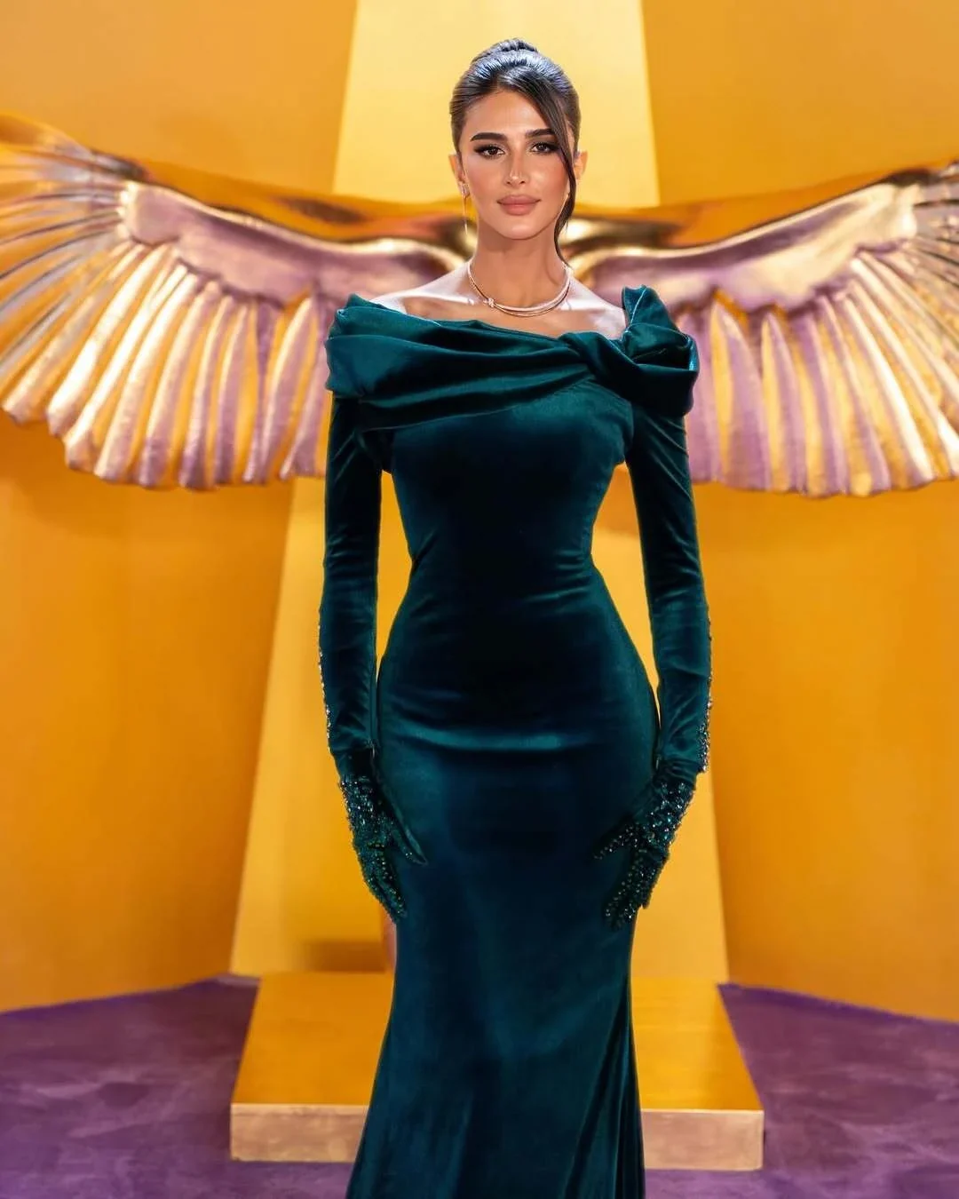 Rahaf in front of a golden wing installation at the Joy Awards